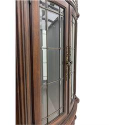  Kevin Charles American walnut demi lune display cabinet with illuminated interior, projecting cornice, two bevel edge glazed doors enclosing two adjustable shelves above single drawer and four cupboard doors with wine rack, carved scrolling supports