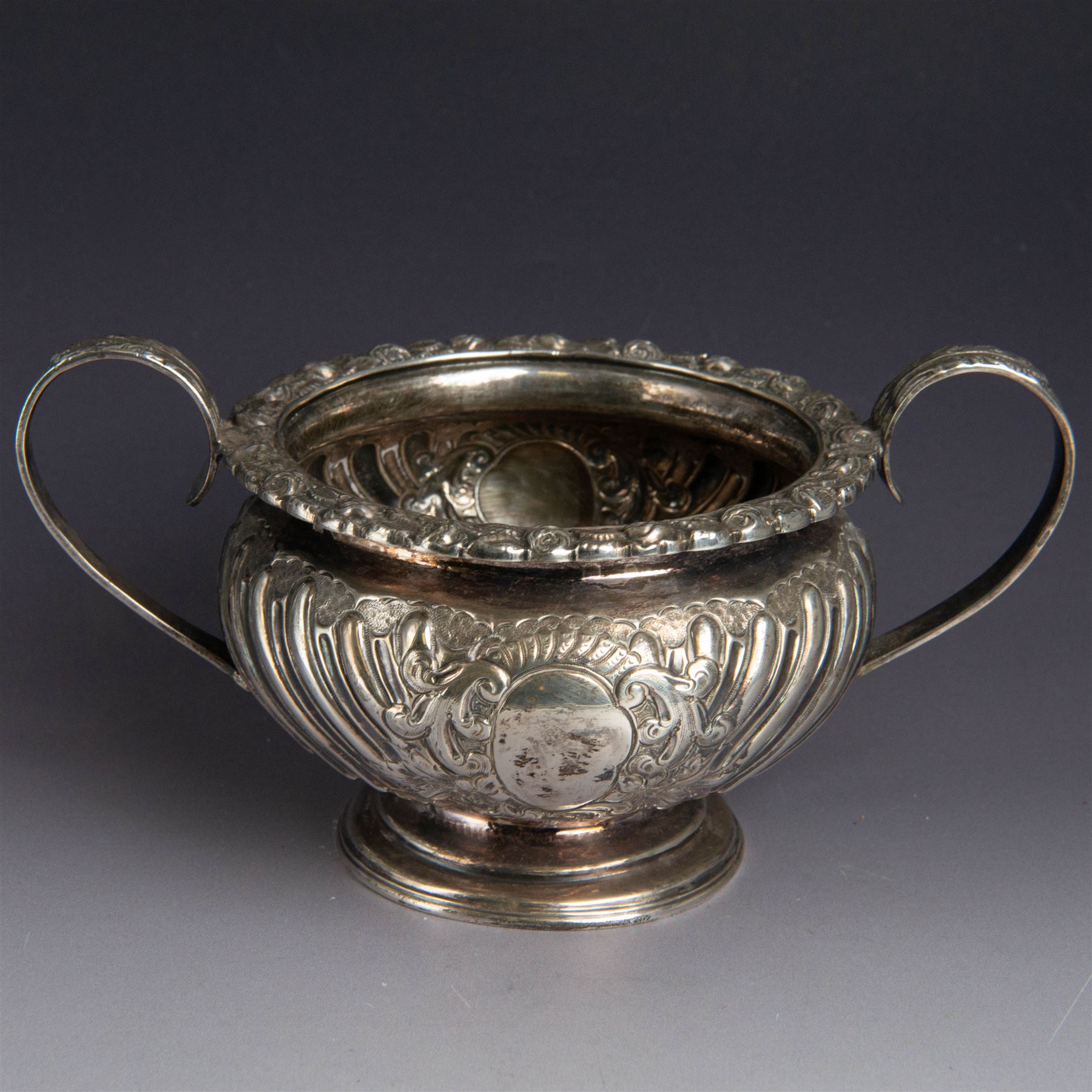 Victorian silver four piece tea service, comprising hot water pot, teapot, milk jug and sugar bowl, of circular part fluted bellied form, with embossed and engraved floral decoration, engraved with initials to body, the teapot and hot water pot with wooden handles and finials, hallmarked Z Barraclough & Sons, Sheffield 1898