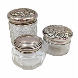 Three cut glass dressing table jars, each with hallmarked silver lids