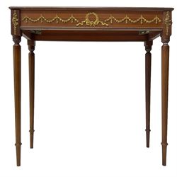 Early 20th century mahogany side table, inset amber leather surface, frieze decorated with applied gilt festoons and central wreath, on tapering fluted supports
