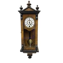 German - miniature 8-day timepiece wall clock in a walnut and ebonised case, with a gable pediment and finials, fully glazed door and ogee base, two-piece enamel dial with Roman numerals , minute track and steel spade hands, visible pendulum with an ebonised rod and brass bob.