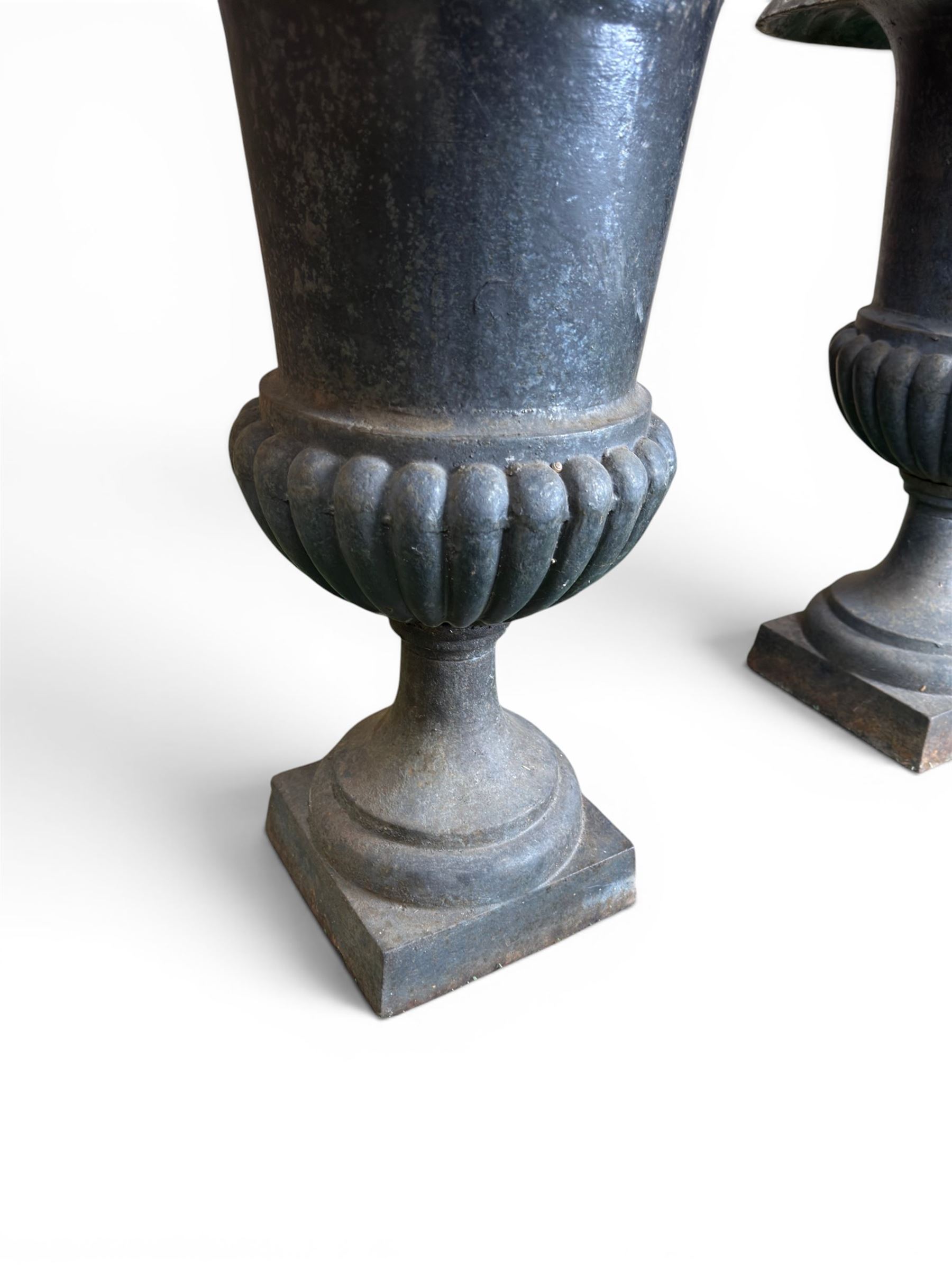 Pair of Victorian design heavy cast iron garden urns, black painted, egg and dart rim on waisted column