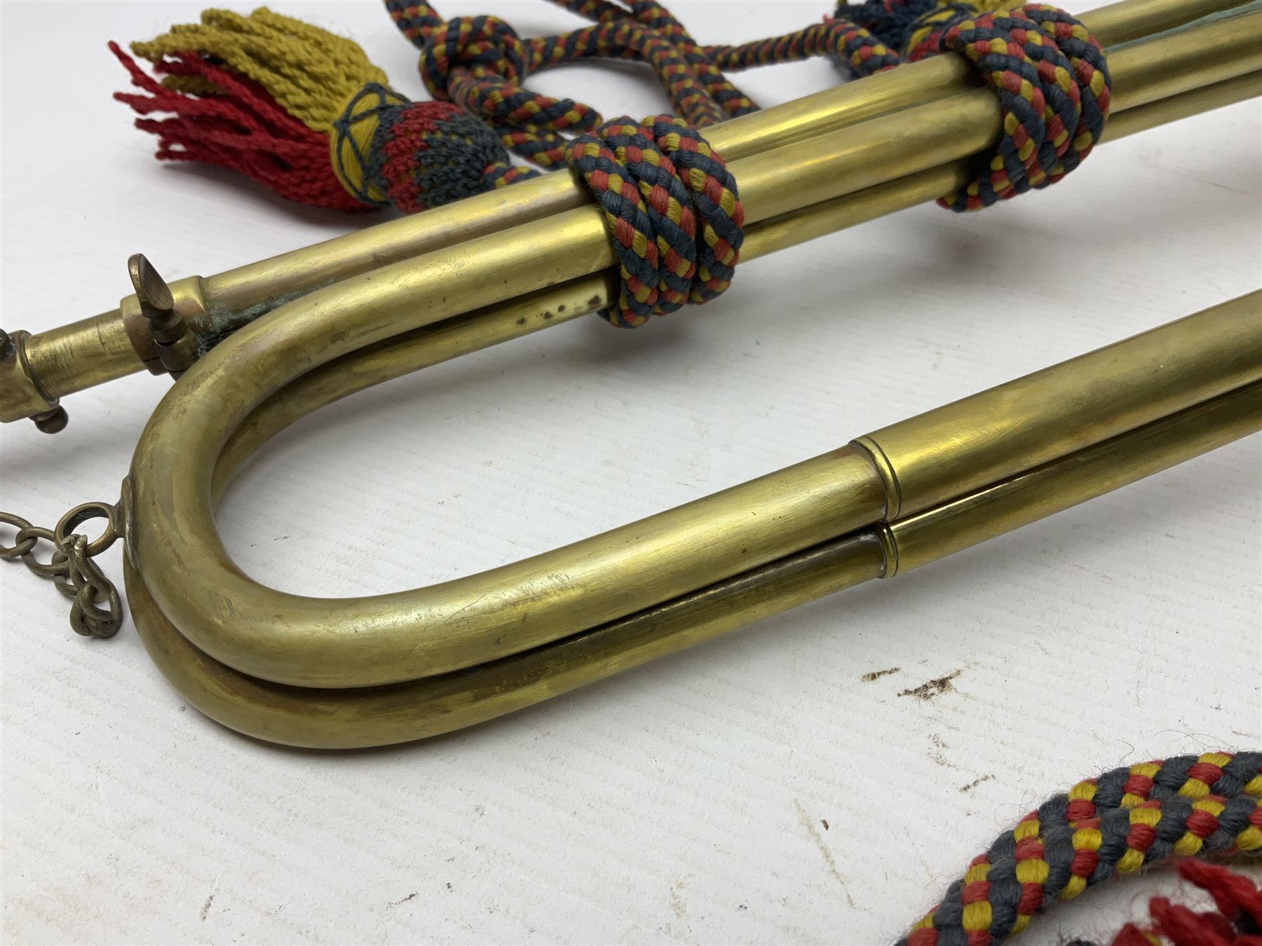 Two military brass bugles by Mayers and Harrison Ltd. Manchester each with crows foot mark and dated 1966; both with multi-coloured cord and tassels, longest 52.5cm (2)