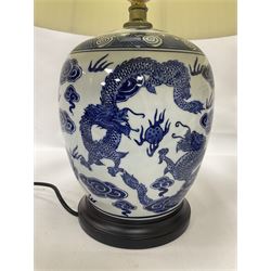 Pair of blue and white table lamps of ovoid form, each decorated with dragons chasing the flaming pearl amidst auspicious clouds, upon circular hardwood bases, excluding fitting H28cm