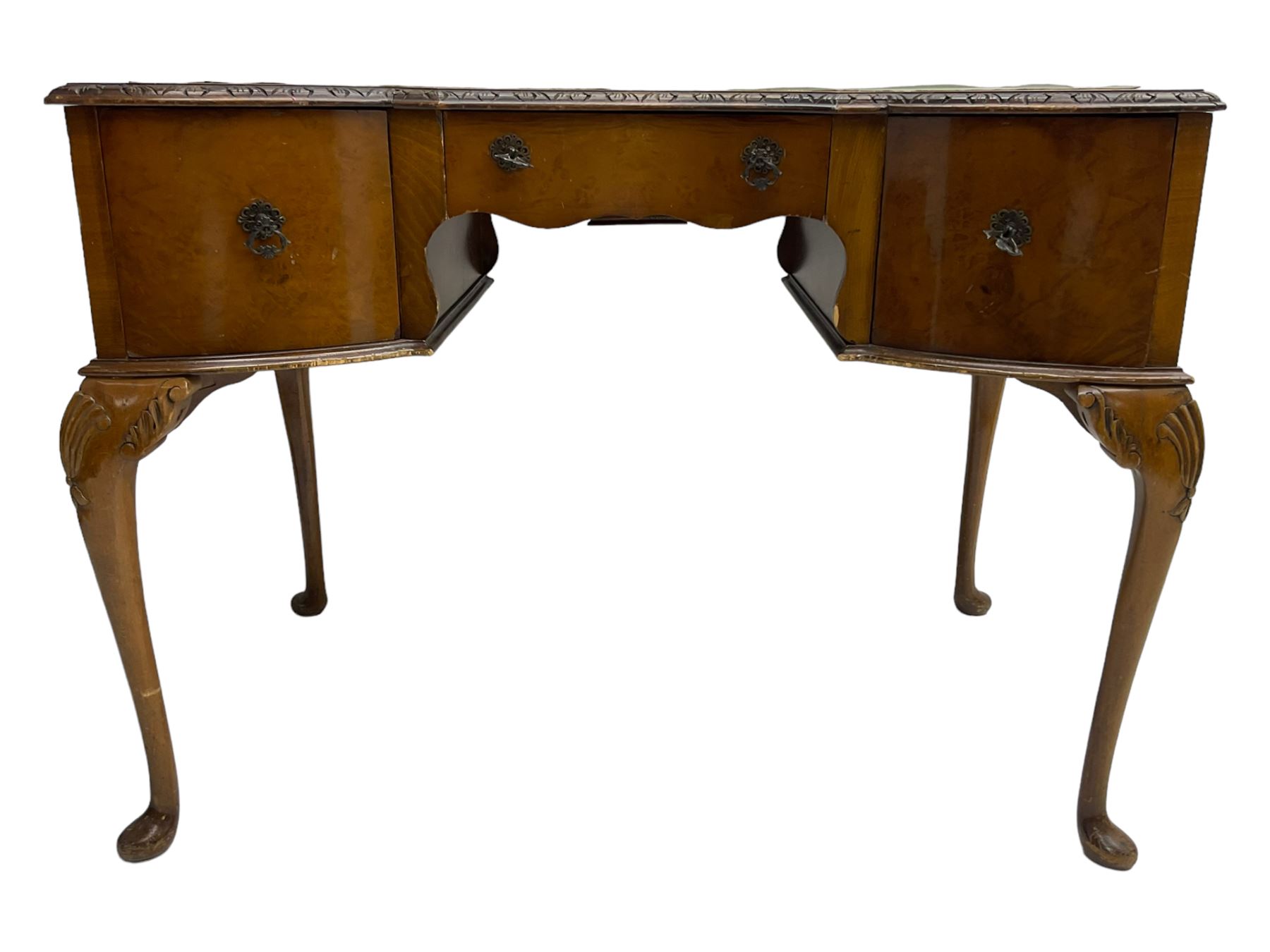 Early 20th century Queen Anne design walnut writing desk, reverse bow-front with inset green leather writing surface and foliate carved edge, fitted with three drawers, raised on cabriole supports