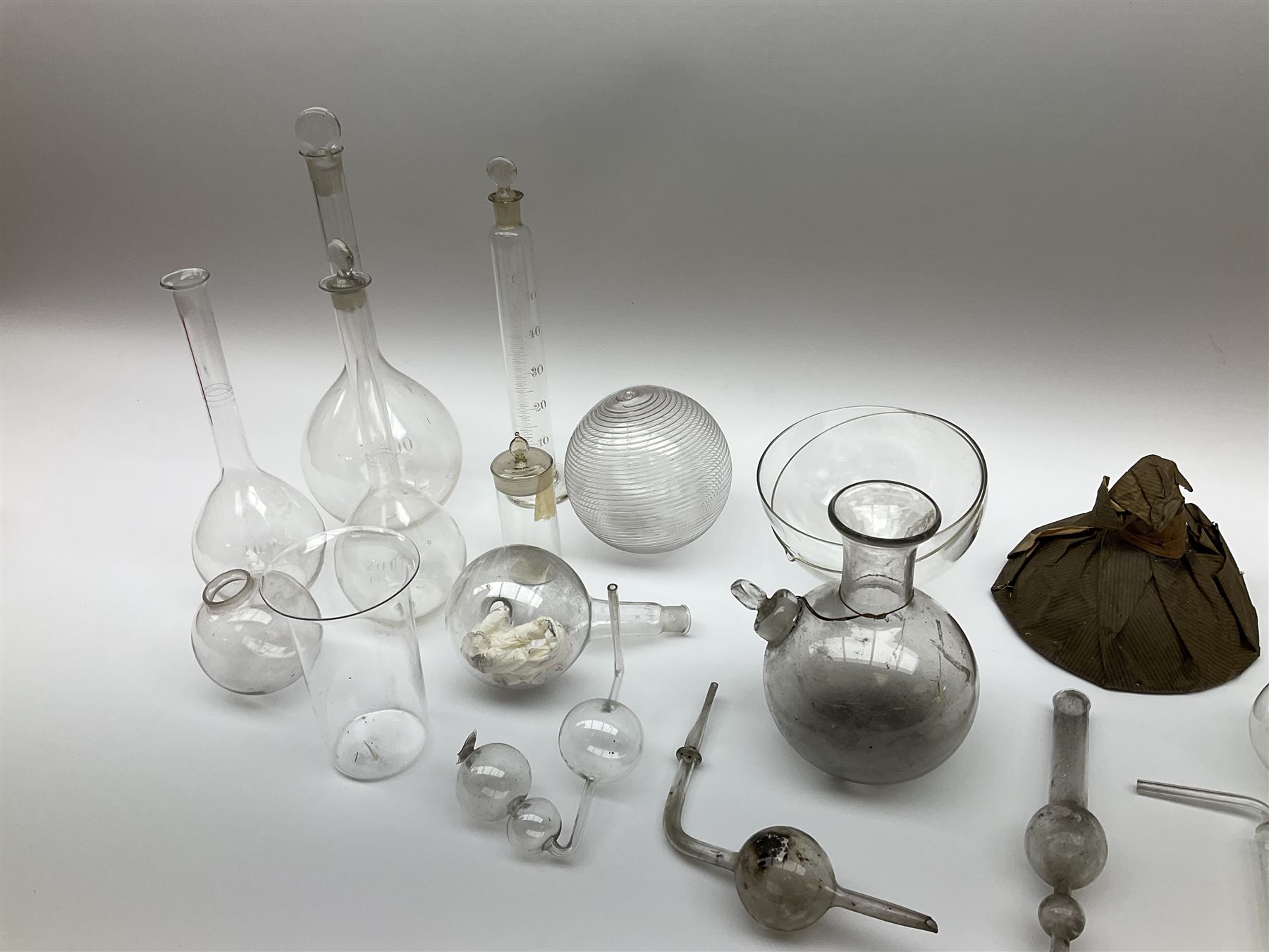 Collection of 19th century and later pharmaceutical laboratory glass, to include, volumetric flasks of various sizes, conical flask, stratus flask, etc (25) Provenance: discovered in the storeroom of a long established Hull pharmacist and opticians