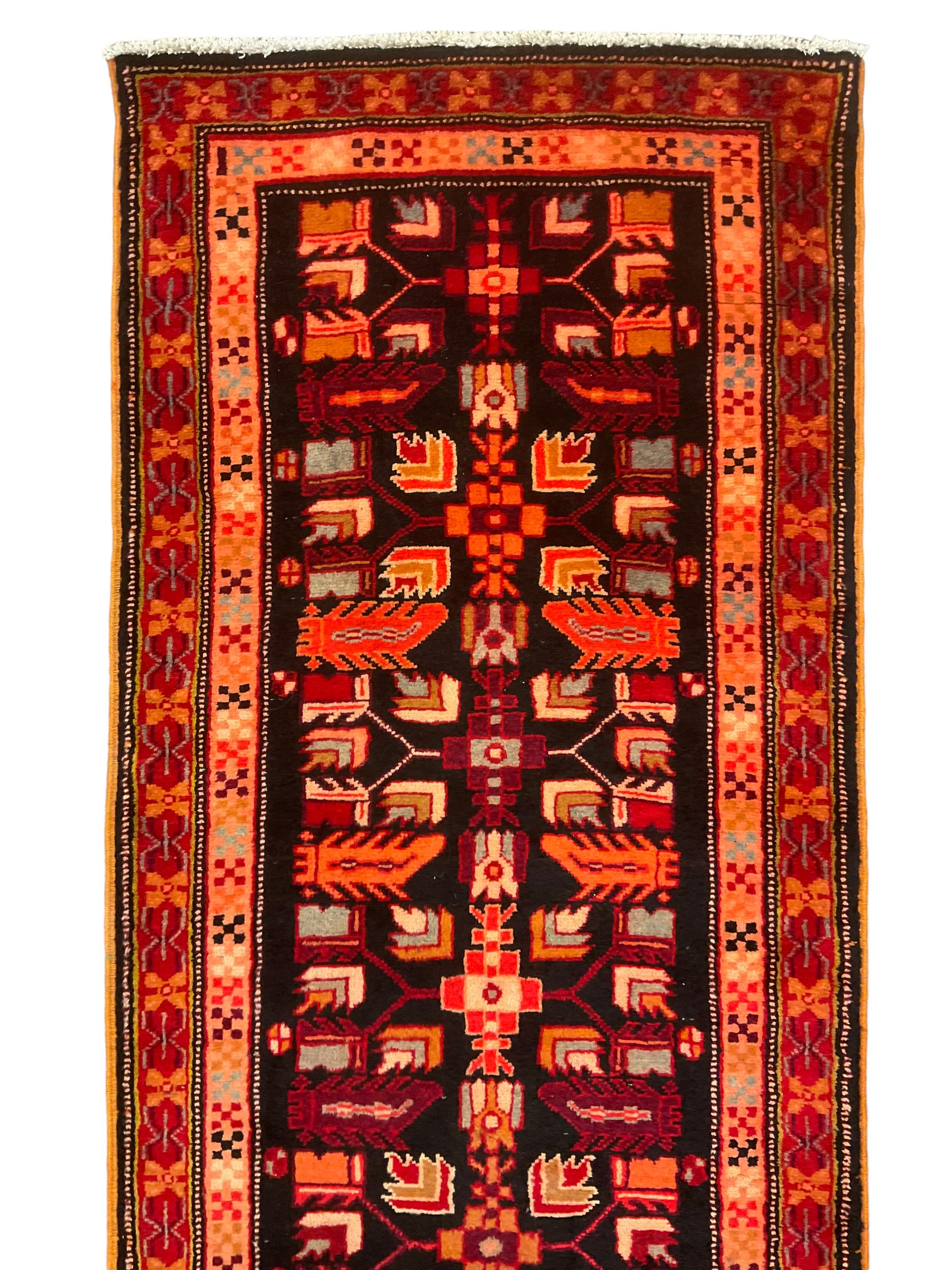 North West Persian Heriz runner, dark indigo ground field decorated with Herati motifs, peach and red borders with geometric design 