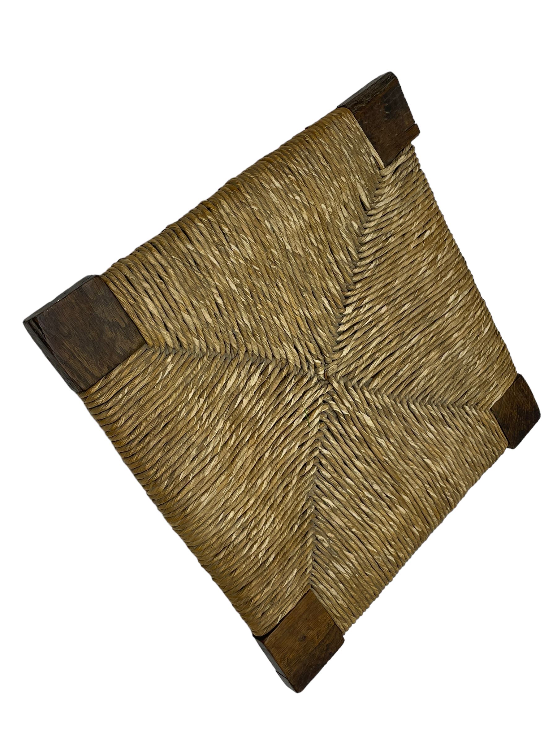 18th century country elm and oak corner chair, the shaped cresting rail terminating to swept arm resets, supported by turned columns and pierced shaped splats, over a drop-in rush seat, raised on square supports united by box stretcher