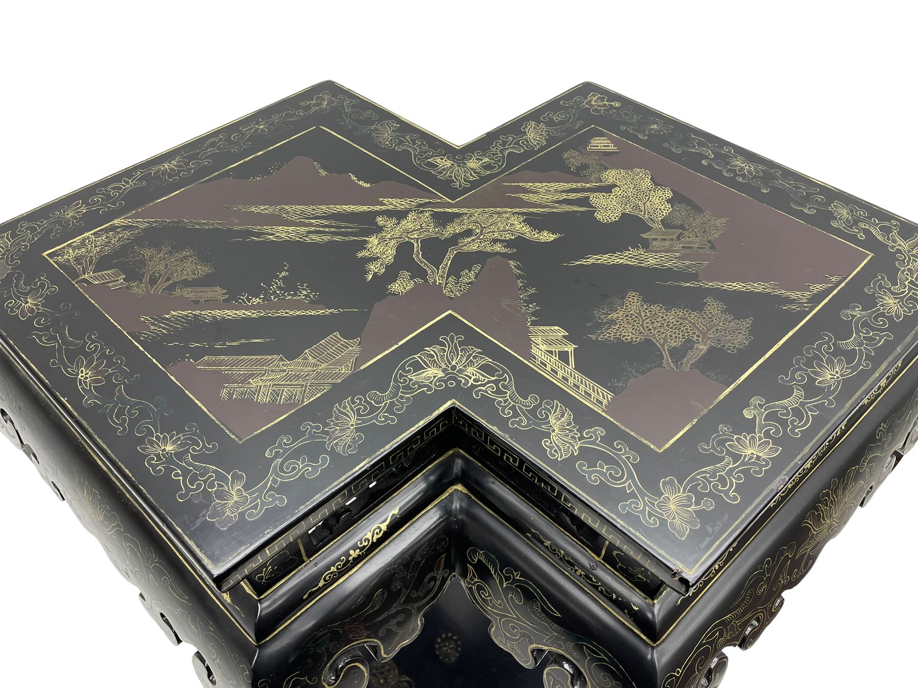 Chinese black lacquer double jardinière stand, the double-lozenge top painted with traditional landscape scenes within a gilt strung border, the pierced frieze with trailing foliate decoration and geometric patterns over the shaped projecting apron, supported on six cabriole supports united by a hexagonal undertier, raised on compressed spade feet