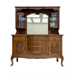 Late Victorian walnut mirror back sideboard or dresser, the raised back fitted with two curved and lead glazed cabinets, central arched bevelled mirror, the sideboard with break bowfront, fitted with six drawers and two cupboards, the cupboard doors panelled and carved with scrolls, shell and plant motifs, shaped apron with cabriole feet
