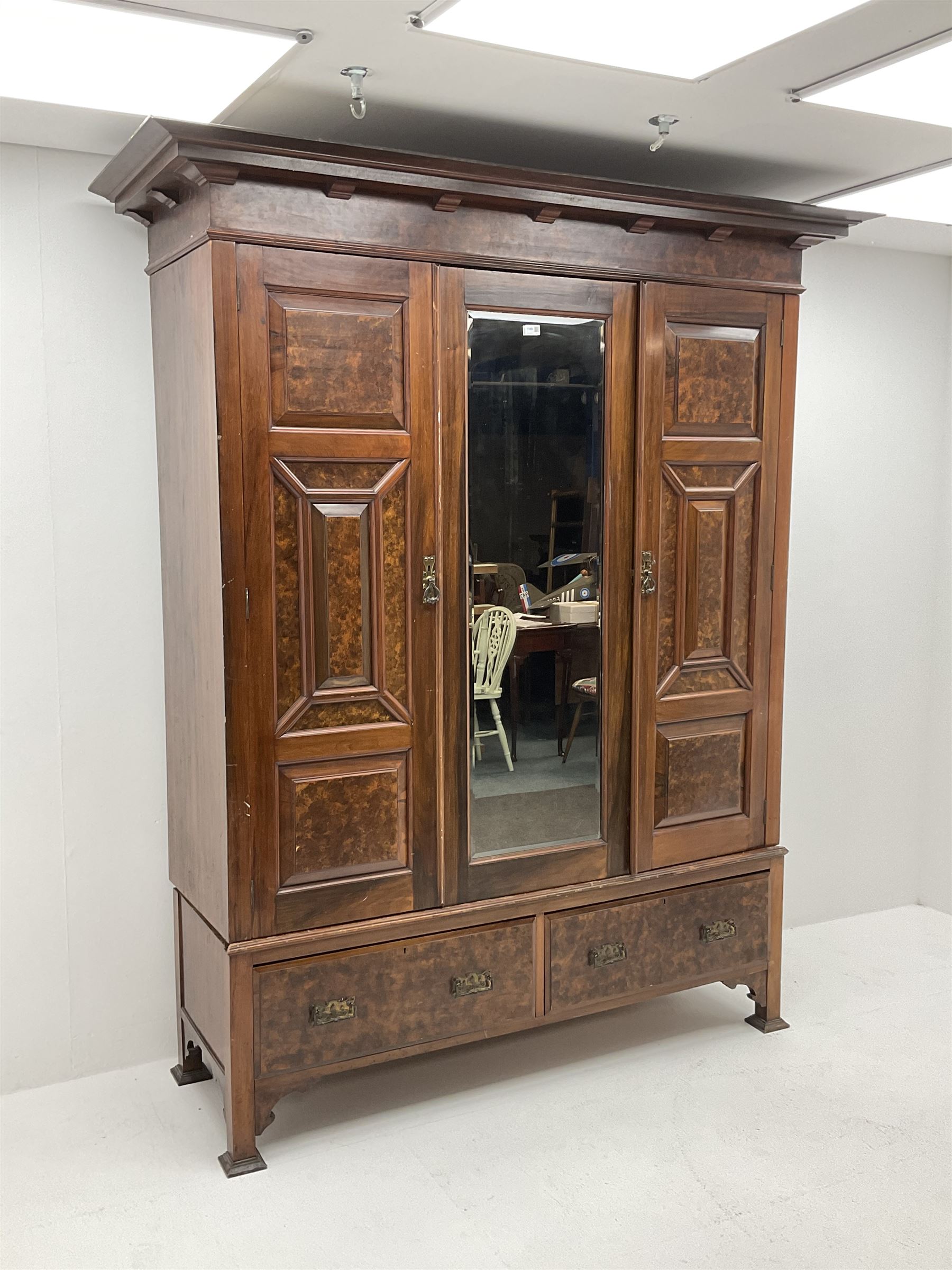 Large late Victorian walnut wardrobe, projecting cornice of central bevelled mirror and two panelled doors, two drawers to base