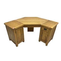 Oak twin pedestal corner desk, one pedestal fitted with single drawer over panelled cupboard door, the other with single cupboard