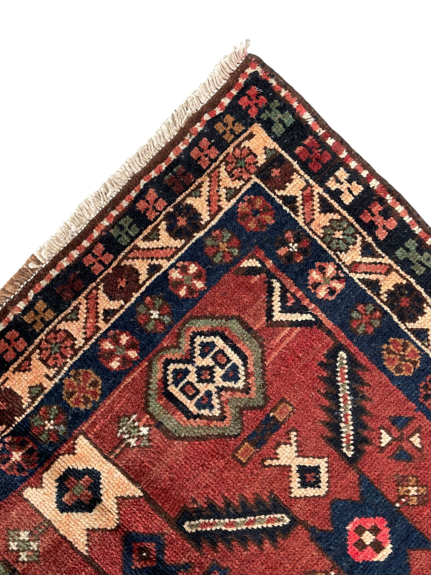 Near pair of Persian Azerbaijan red ground runners, each rug decorated with Nazarlik and stylised leaf motifs, enclosed with three band border decorated with flower heads and geometric motifs 

406cm x 99cm 
409cm x 102cm
