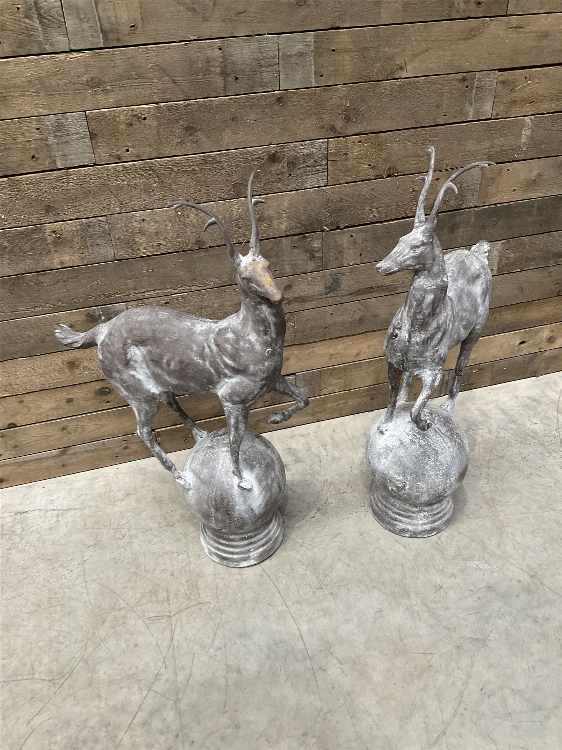 Pair of cast iron garden Stag figures or gate finials, raised on spherical ribbed base 
