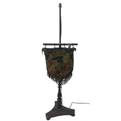 Victorian rosewood pole screen converted to standard lamp, turned column on a triform platform base with compressed bun feet, the beadwork and needlework tapestry depicting a bird amongst foliate