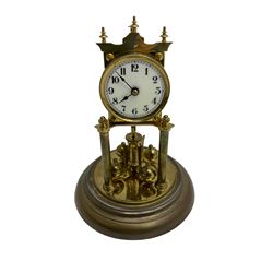 German - 1930's 400-day torsion clock by Jahresuhrenfabrik, movement on a circular brass base supported on two columns, enamel dial with Arabic numerals and spade hands, going barrel movement with a four ball rotary pendulum, suspension present and intact. With a Glass dome. 