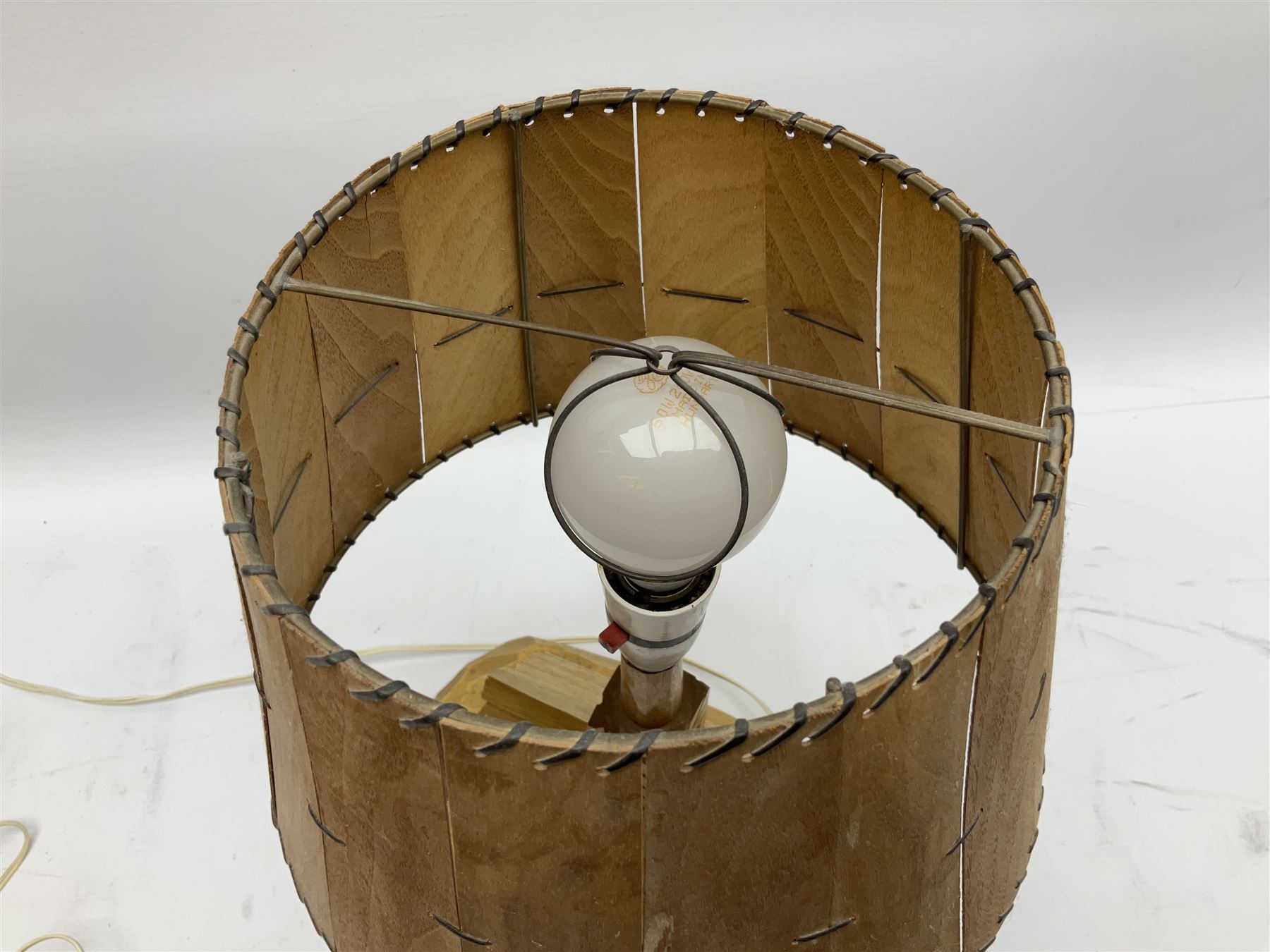 Mid 20th century Paul Caron carved table lamp, modelled as man standing before an oven, the chimney supporting the panelled shade, the base signed P.E. Caron, H42cm