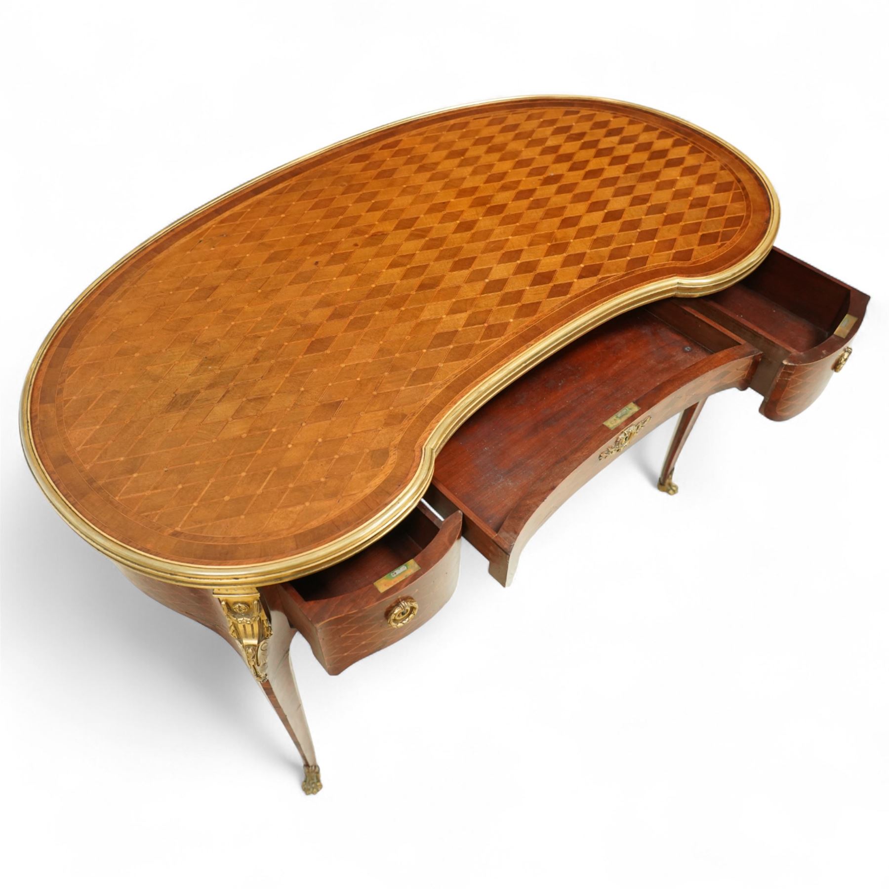 Late 19th-century Louis XV-style marquetry and gilt bronze-mounted kidney-shaped writing table, of serpentine form, top finely veneered with a trellis parquetry pattern, within a gilt bronze moulded edge, above a shaped frieze fitted with a central drawer flanked by two short drawers, similarly inlaid side and legs, knees with gilt bronze foliate mounts and cabriole legs terminating in gilt bronze sabots