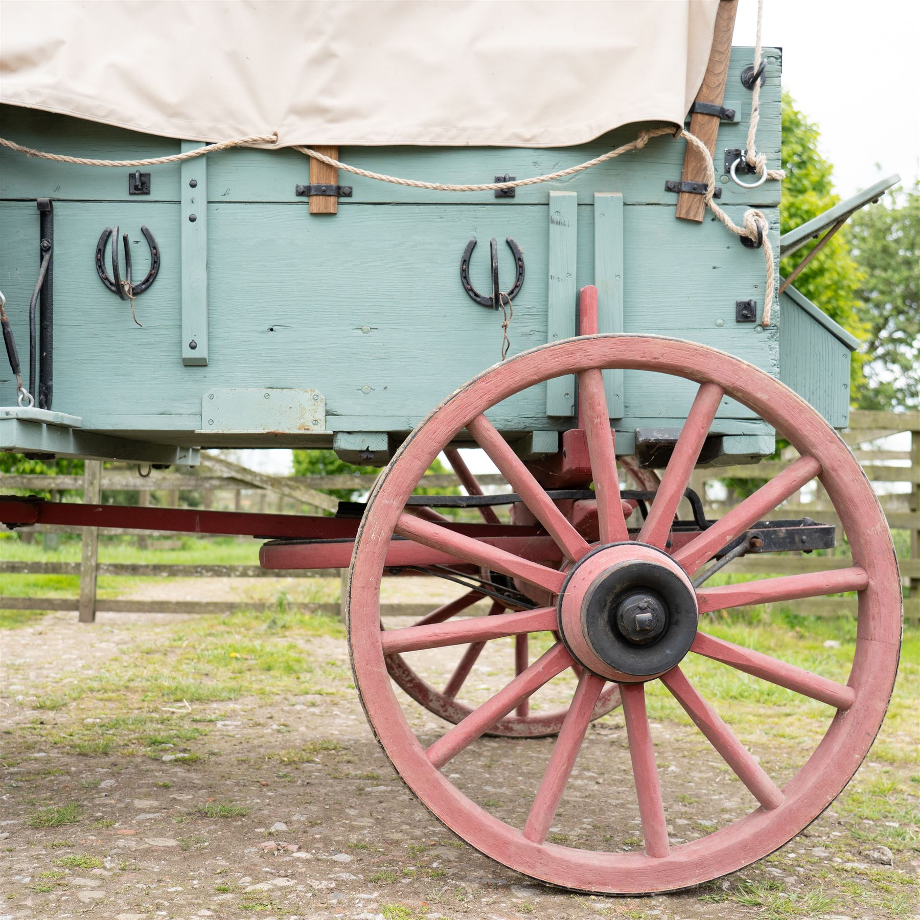 Western Covered Chuck Wagon

A large four wheeled covered wagon of timber construction, painted pale green with red painted wooden spoked wheels and a cream canvas tilt over an arched frame. The wagon has a traditional box body with covered rear compartment, front driving position, underbody turntable steering and iron fittings throughout. Fitted with external equipment details including a side mounted barrel, lidded storage chest, rope tie downs, horseshoe fittings and rear storage box.

Features

• Pale green painted timber body
• Cream canvas tilt over arched frame
• Covered rear compartment
• Front driving position
• Side mounted barrel
• External lidded storage chest
• Rear storage box
• Wooden spoked wheels
• Iron tyres
• Underbody turntable steering
• Rope tie downs
• Horseshoe fittings
• Iron hardware and brackets
• Brass restoration plaque to rear

Dimensions:
Overall length: 335 cm
Width: 170 cm
Height: 275 cm

Wheel Diameters:
Front wheels: 92 cm
Rear wheels: 112 cm

Seating:
Driver: 1
Passenger: Rear covered compartment