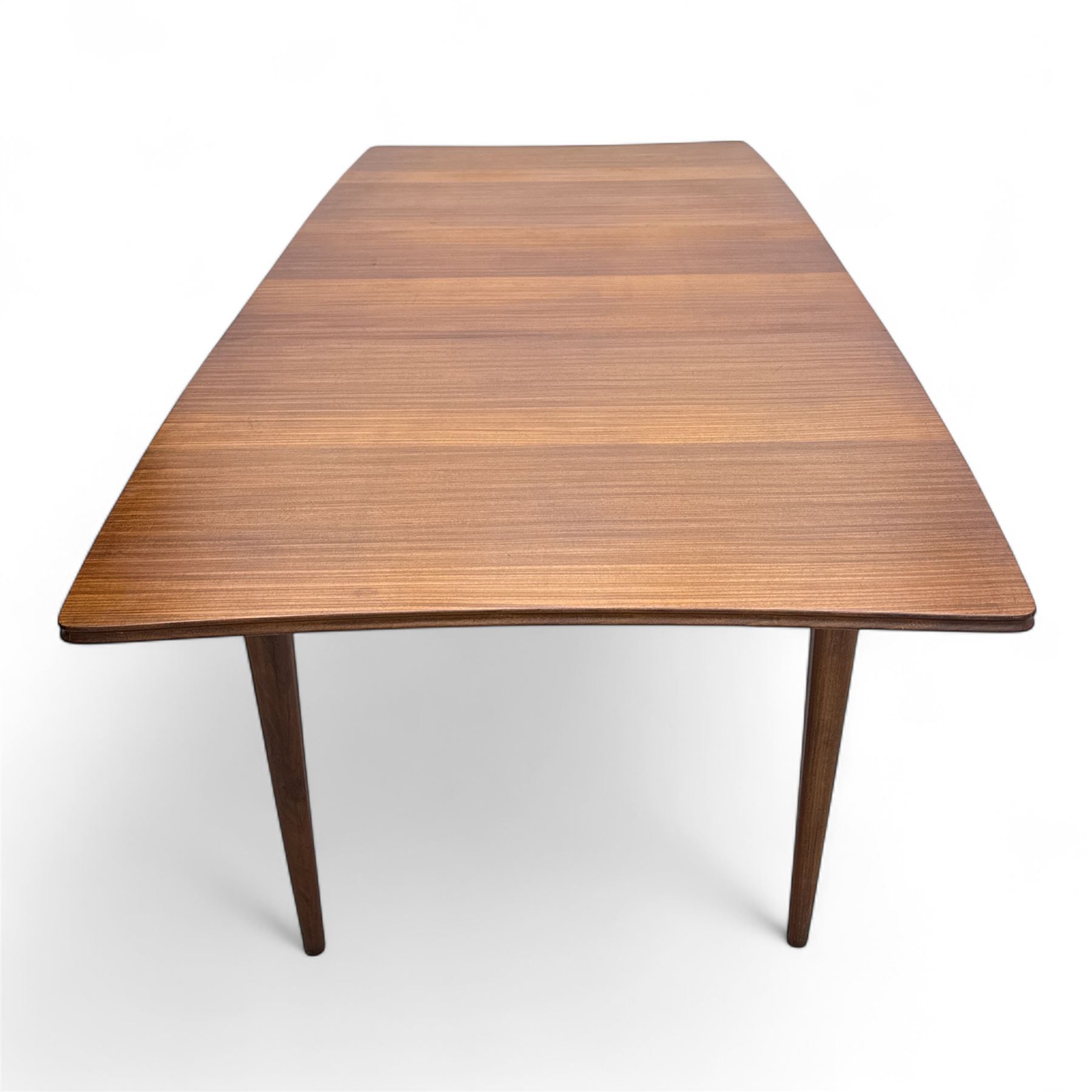 Richard Hornby for Fyne Ladye - mid-20th century afromosia teak dining table, tapered rectangular top with fluted edge and recess for spare leaf, raised on slender legs, teak framed chairs, of ladder back design, with drop-in seat, upholstered seat, with tapered front legs and slightly raked rear legs, retailed by Heals of London, table extended width 181cm depth 86cm height 74cm - chairs width 48cm depth 41cm height 87cm 