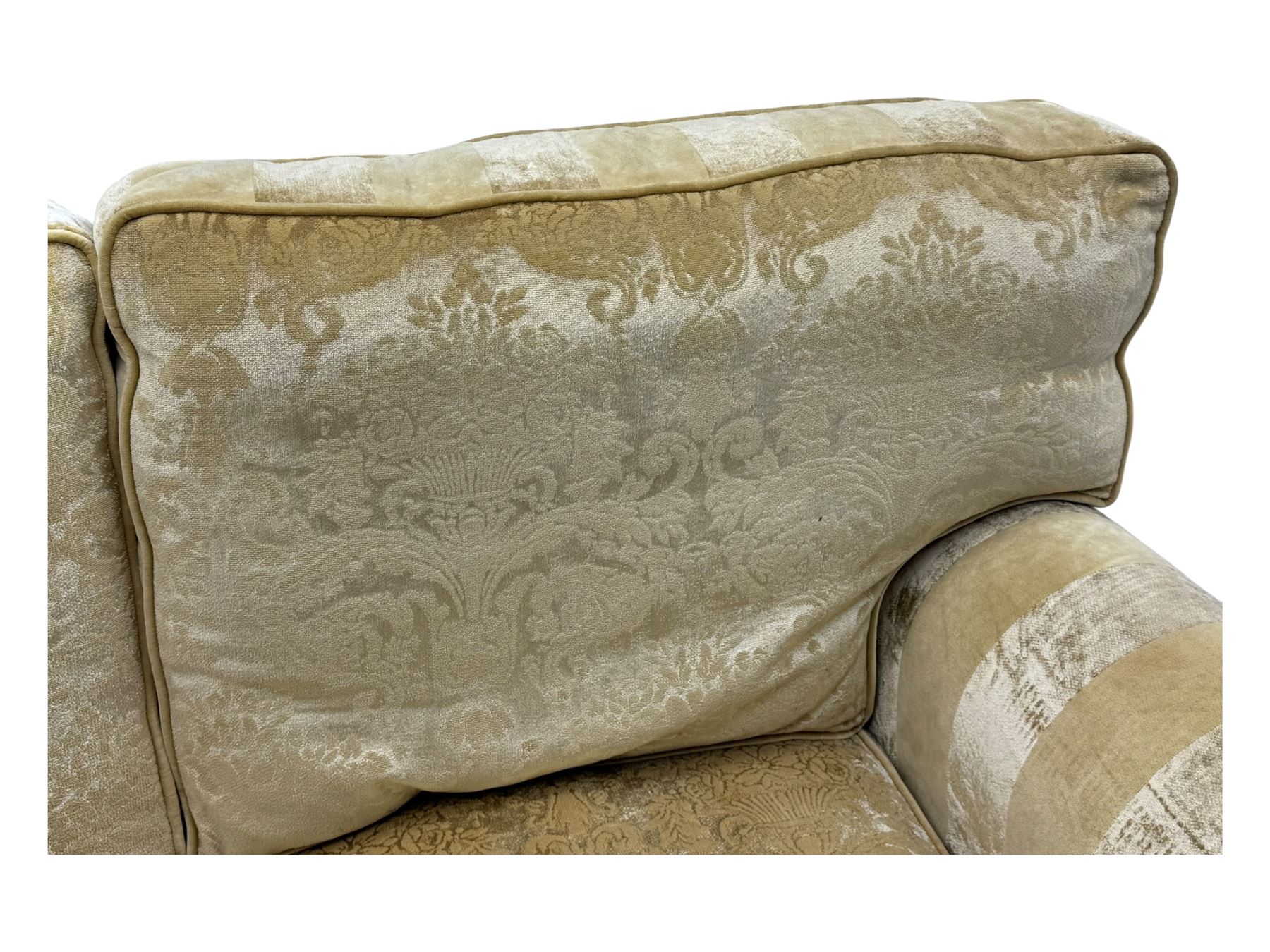 Contemporary two-seat sofa, upholstered in damask fabric with a pale gold floral pattern, rolled arms with covers, loose back and seat cushions, on matching skirted base with concealed castors
