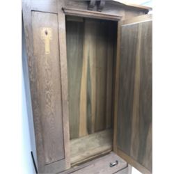 Arts and Crafts period oak wardrobe, projecting shaped cornice, single bevel edged mirrored door above drawer