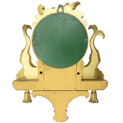 20th century Continental giltwood wall clock, circular dial with Arabic numerals and pierced gilt hands, within a carved case surmounted by a scrolling crest and flanked by stylised dolphins, above a shaped shelf with tassel pendants and a foliate terminal, pendulum missing