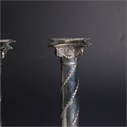 Pair of Edwardian silver mounted column candlesticks, each with embossed floral, foliate and scrolling decoration and upon stepped square weighted bases, hallmarked William Hutton & Sons Ltd, London 1901, H19cm