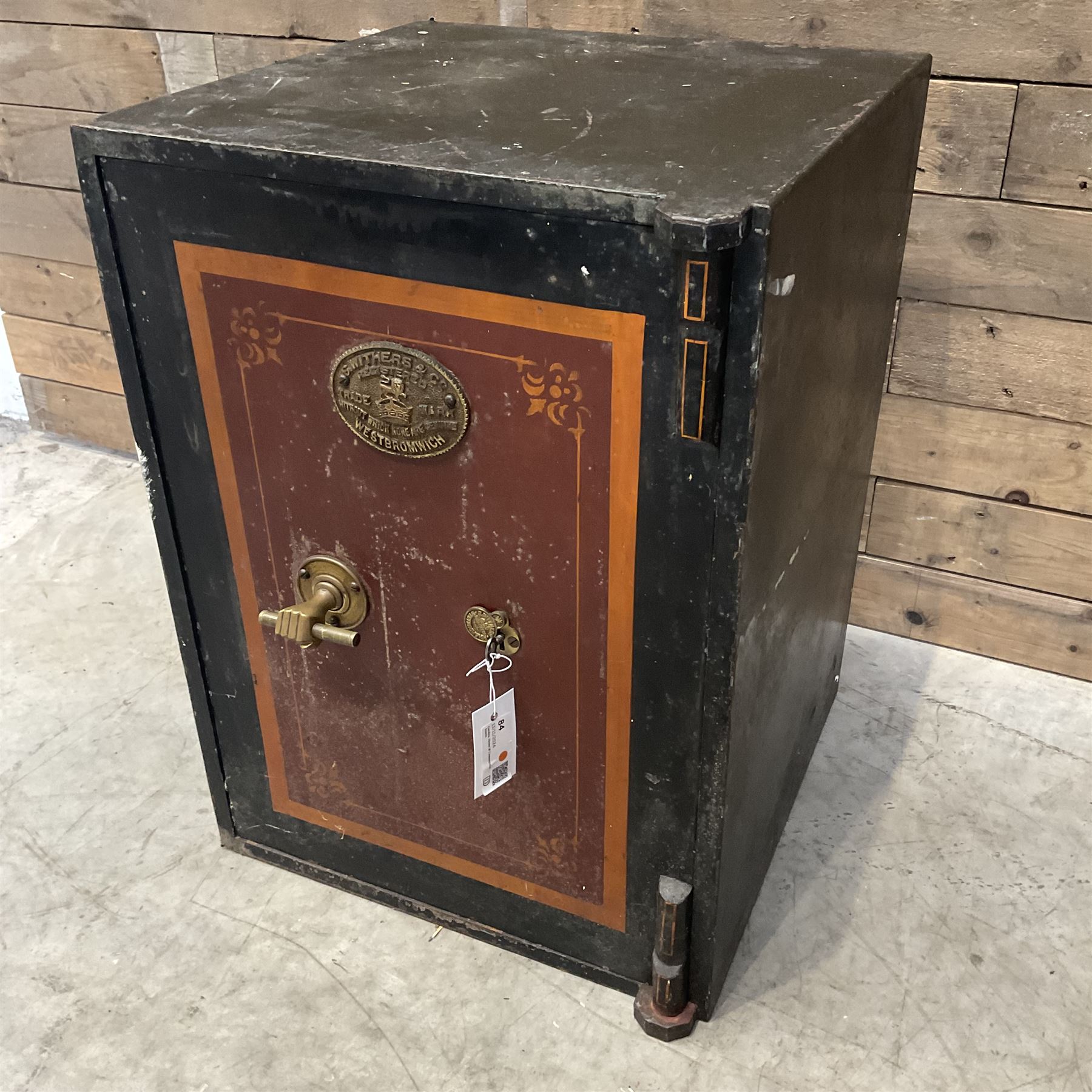Samuel Withers & Co of West Bromwich - Victorian cast iron safe, the brass handle modelled as a clenched fist, painted in red, orange and black, with key. Ground floor delivery only, no steps.