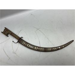 Late 19th/early 20th century Moroccan nimcha dagger-sword, the 40cm curving steel blade with engraved decoration on both sides; shaped hardwood hilt inlaid with brass, white metal wires and red coloured panels; in similarly inlaid scabbard L61cm overall