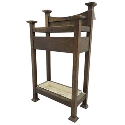 Early 20th century Arts & Crafts oak stick stand, panelled back over three divisions, fitted with metal drip tray, on square supports