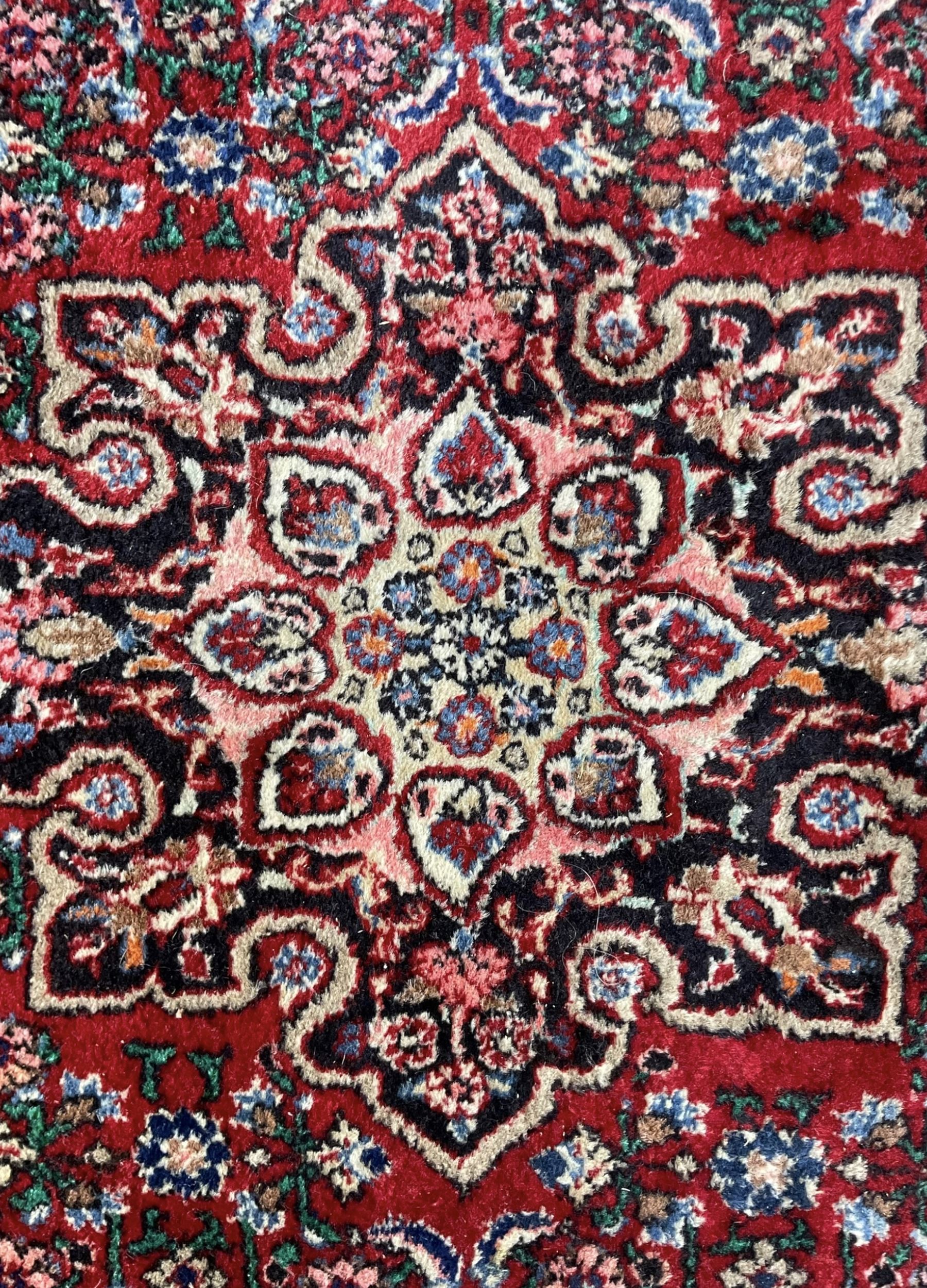Persian design crimson ground rug, the field decorated with central