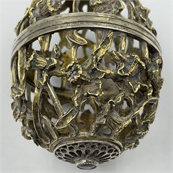Modern silver limited edition Easter egg, no. 70/500, the gilt openwork body decorated with daffodils and detachable cover with pierced circular panel set with a single faceted blue stone, opening to reveal a gilt interior, upon silver stand with three scrolling pad feet, each hallmarked St James House Company, London 1980, height including stand 8cm