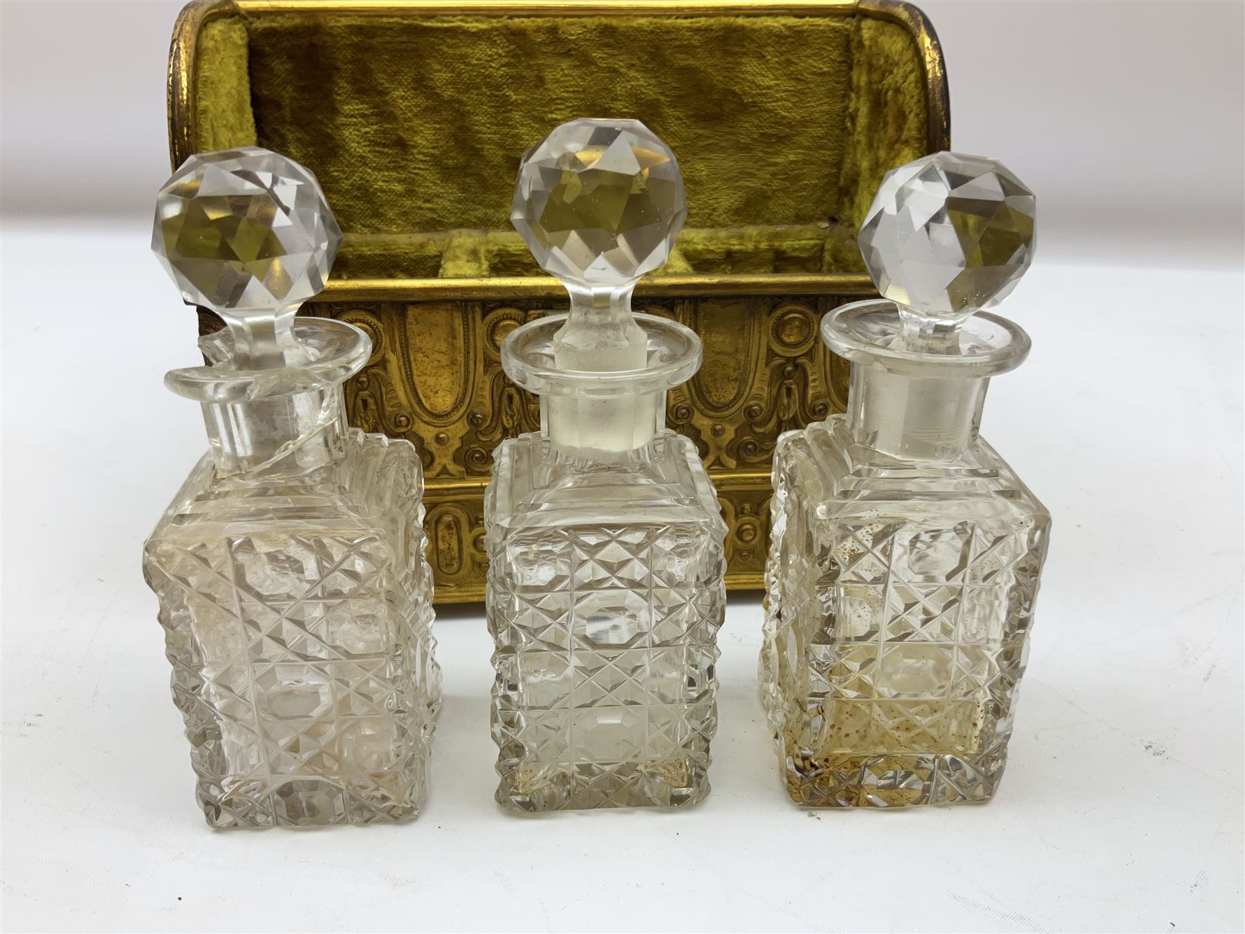 19th century brass repoussé perfume box, the ornately decorated casket with hinged domed cover lifting to reveal gold velvet lined interior containing three glass scent bottles, H14cm W15cm D7cm