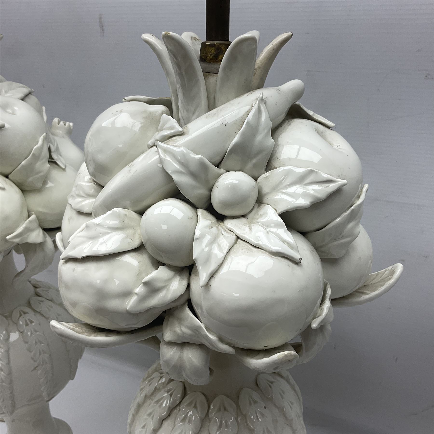 Pair of Casa Pupo white-glazed table lamps, modelled as a fruit upon a column of baluster form with foliate decoration, on a giltwood base, H62cm