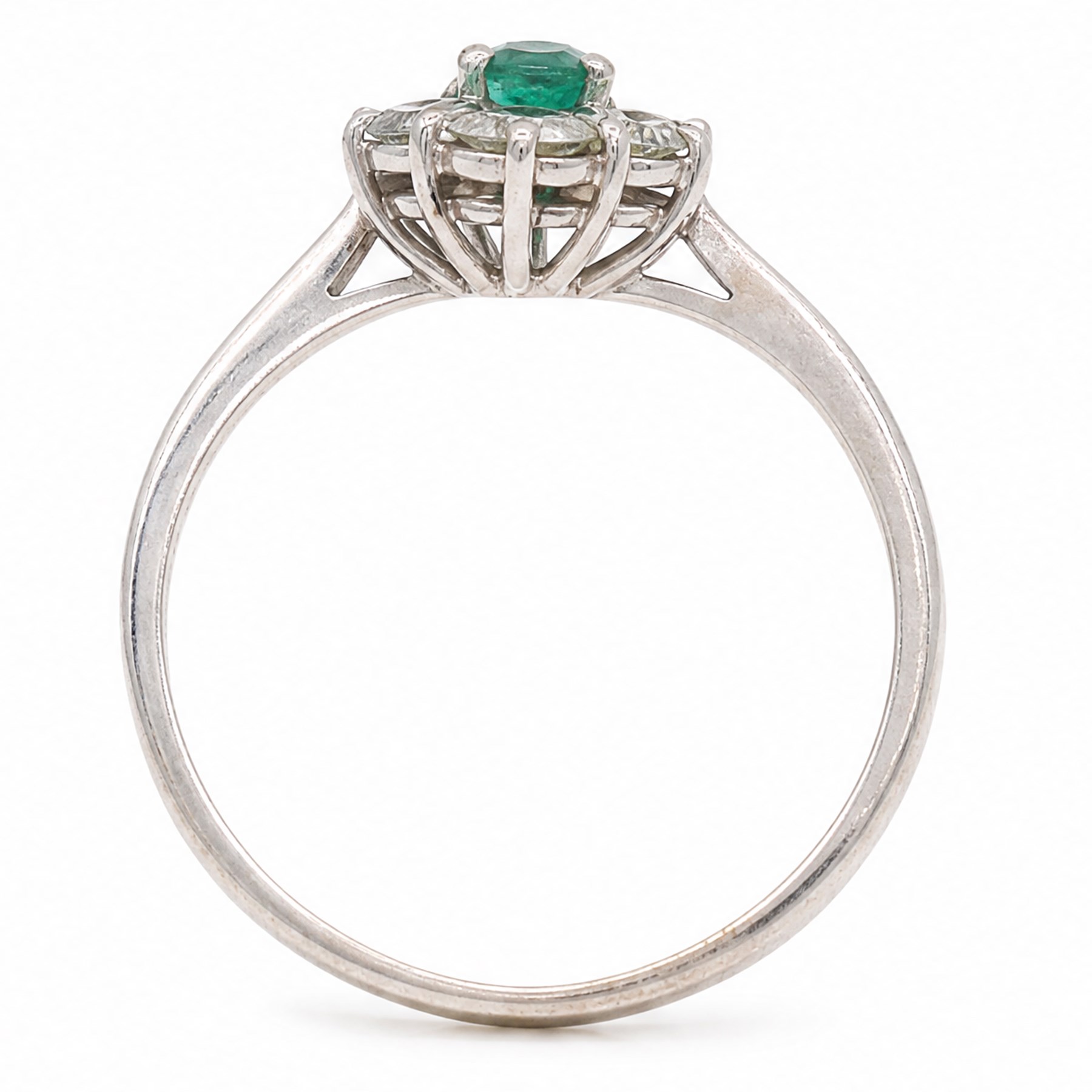 White gold emerald and diamond cluster ring, single oval cut emerald of approx 0.25 carat, surrounded by six round brilliant cut diamonds, stamped, total diamond weight approx 0.30 carat