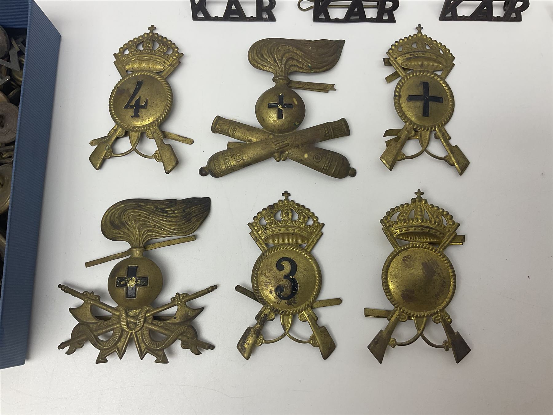 Over thirty British and Continental military metal badges; together with quantity of shoulder titles, collar dogs, rank pips, uniform buttons etc