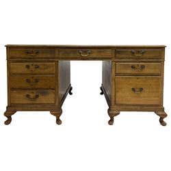 Early 20th century mahogany twin pedestal desk, the moulded rectangular top with three sectional leather insets with gilt decoration, fitted with eight drawers, on cabriole feet