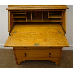  Early 20th century light oak bureau bookcase, stained and leaded glass doors enclosing two adjustable shelves above fall front with fitted interior, three graduating drawers W91cm, H194cm, D39cm  