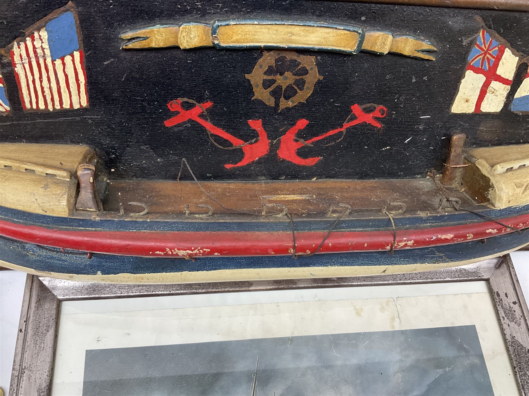 RNLI collection box in the form of a boat makers half block model, painted in the colours of a lifeboat with flag and ship motifs, H25cm, L73cm together with framed photos, postcards and prints of lifeboats and crew, including Scarborough lifeboat station