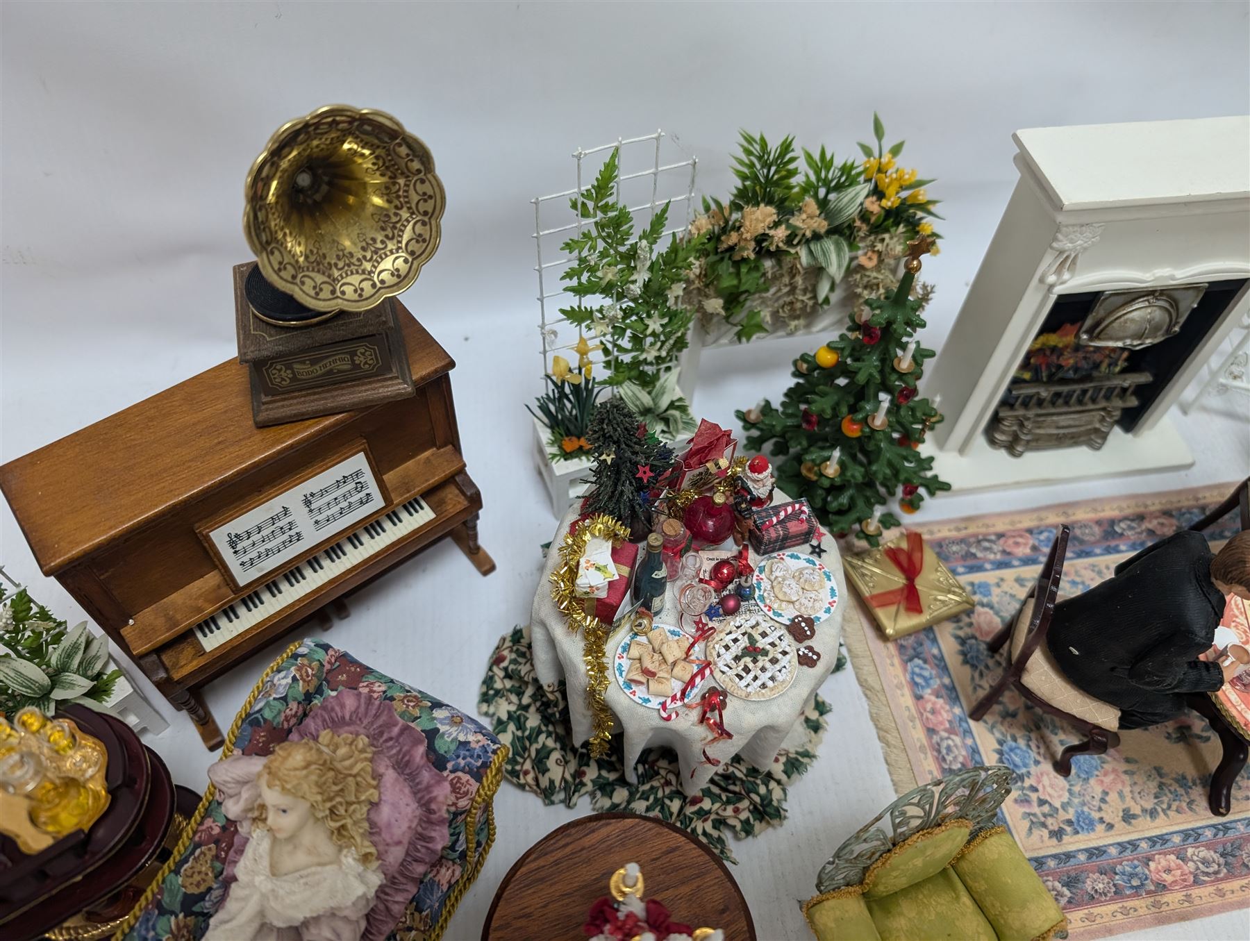 Dolls house furniture, including pianos, fireplace, plants, flower arrangements, tables, chairs, six figures and a collection of instruments and other accessories