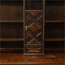19th century Jacobean Revival oak dresser and rack, the upper section with open shelves and central cupboard, flanked by bobbin moulded uprights, the base fitted with three carved drawers with brass ring handles, raised on turned supports united by stretchers