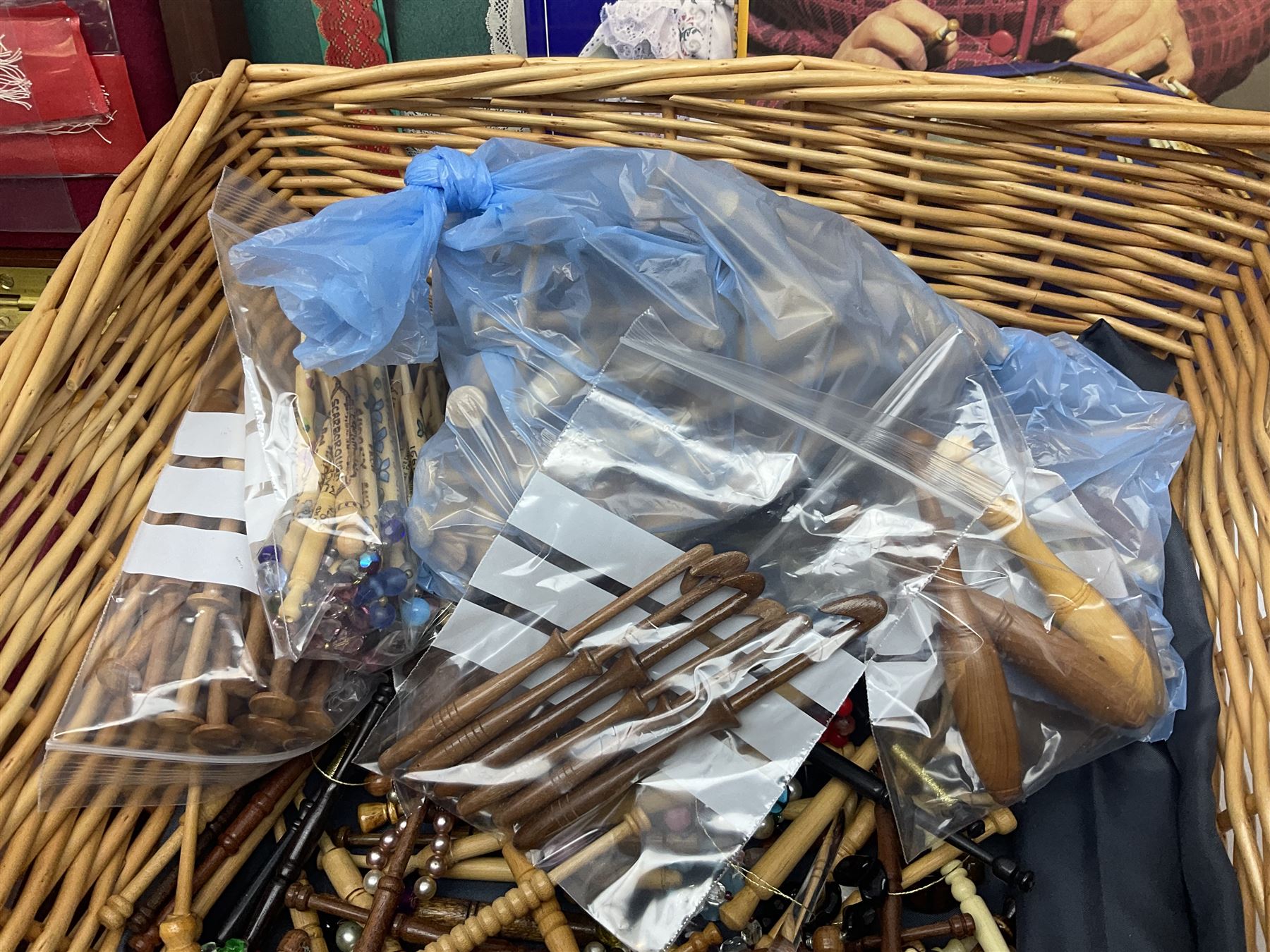 Collection of lace making wooden bobbins, together with lace making books and a handmade storage box