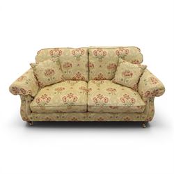 Parker Knoll - 'Henley' floral fabric living room suite, comprising a two seat sofa and pair of armchairs, raised on dark stained turned feet raised on brass castors

Armchairs (H 99cm, W 95cm, D 100cm)