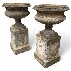 Pair of 20th century cast stone urns on plinths 