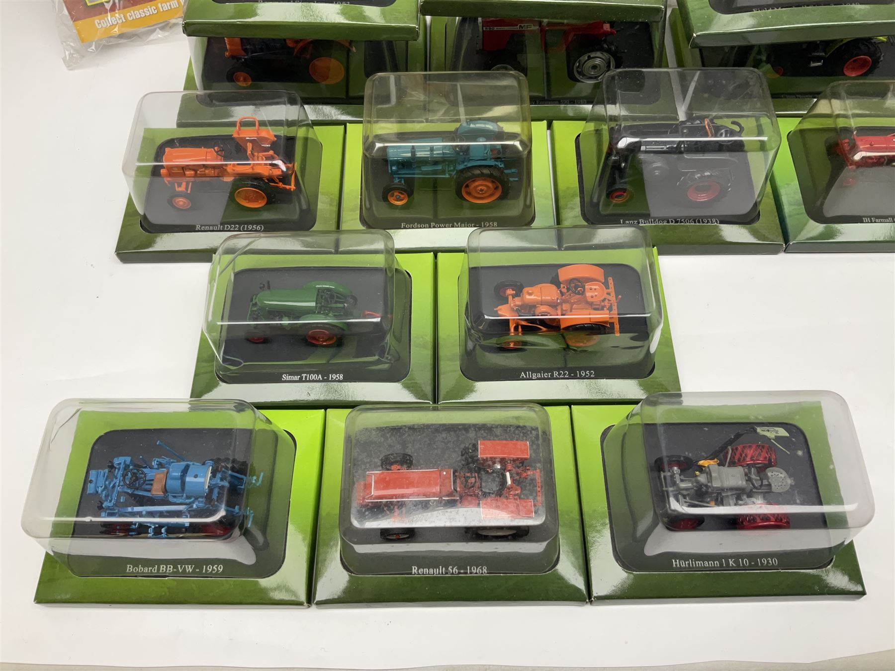 Eighteen issues of Tractors and The World of Farming magazine, together with sixty diecast tractors, all in original packaging, in three boxes 