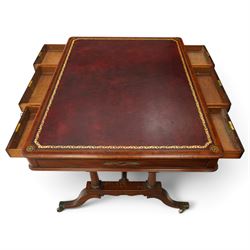 Regency inlaid mahogany and brass mounted library table, the rectangular top inset with gilt tooled burgundy leather writing surface, enclosed by  crossbanding and boxwood stringing with roundel corner motifs, above three cock-beaded frieze drawers to either side fitted with brass ring handles and brass escutcheons, the end friezes centred by applied brass foliate mounts, raised on twin reeded column supports over rectangular platform ends, united by a ring-turned stretcher, the reeded sabre legs terminating in brass caps and castors, one drawer bearing ivorine label 'Spillman & Co., St Martins Lane, London'