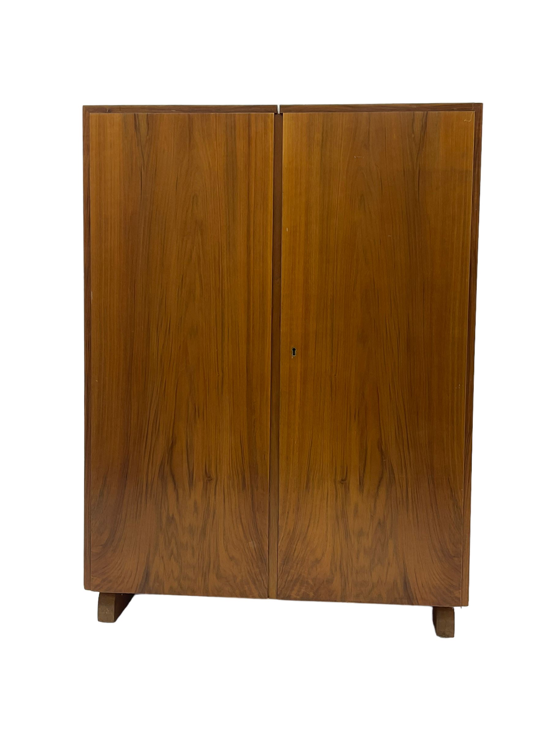 Mid-20th century walnut 'Magic Box' design metamorphic desk cabinet, two doors open to reveal sliding desk with drop leaves, document divisions and internal lamp, on sledge supports 
