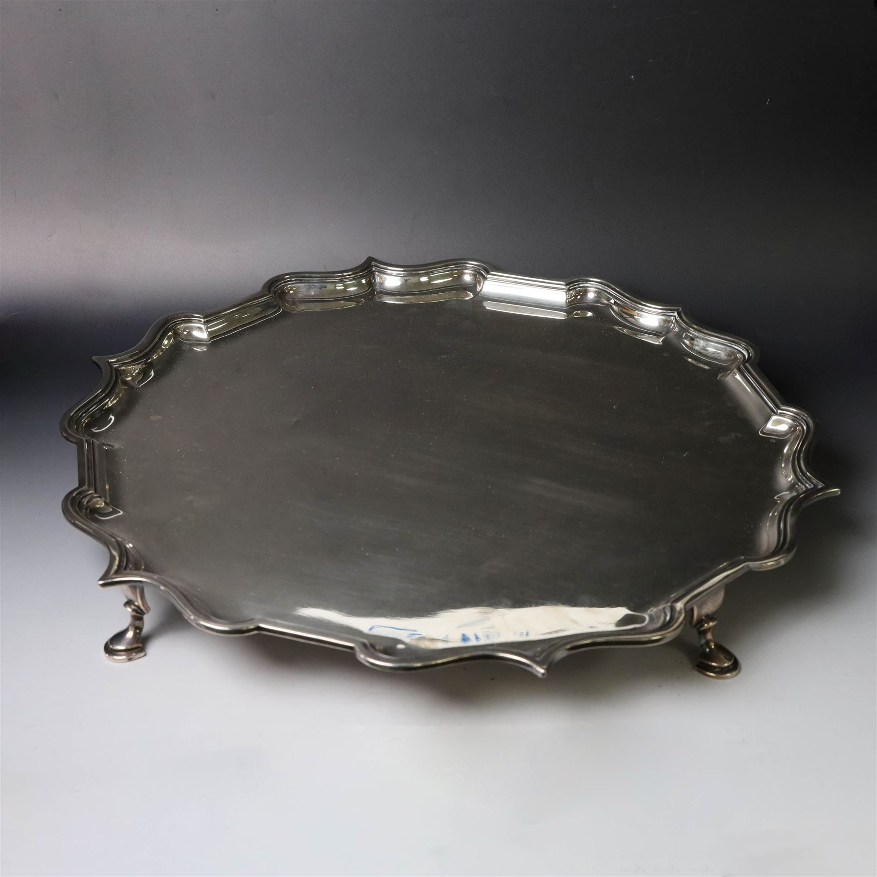 Early 20th century large silver salver, of circular form with Chippendale style rim, upon four hoof feet, hallmarked Elkington & Co Ltd, Birmingham 1918, D47cm