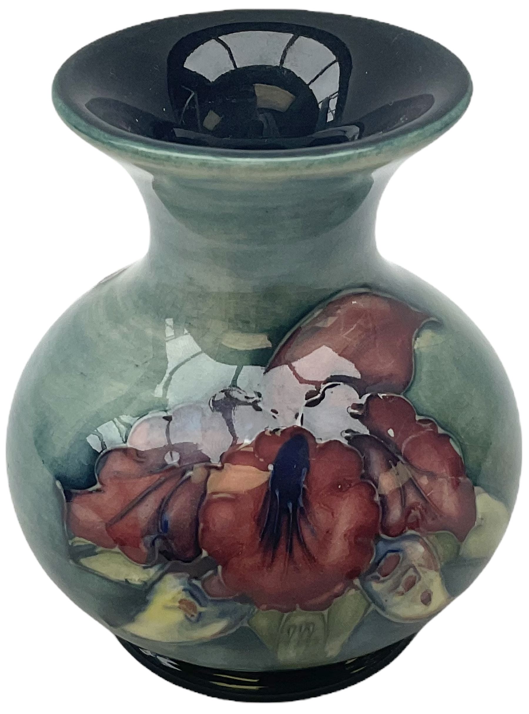 Moorcroft vase, decorated in the Leaf and Berries pattern upon a tonal green ground, together with a further Moorcroft vase, of squat baluster form, decorated in the Iris pattern upon a tonal green ground, each with impressed marks beneath, each H9cm. 
